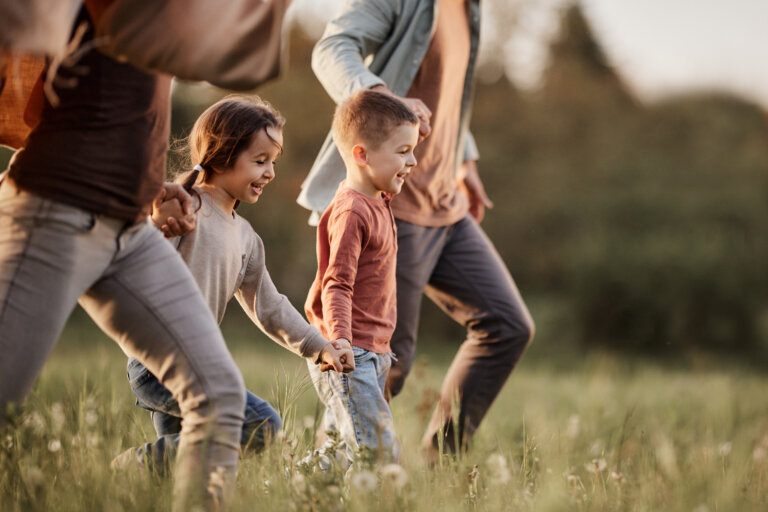 Carefree kids running with their parents in the park.